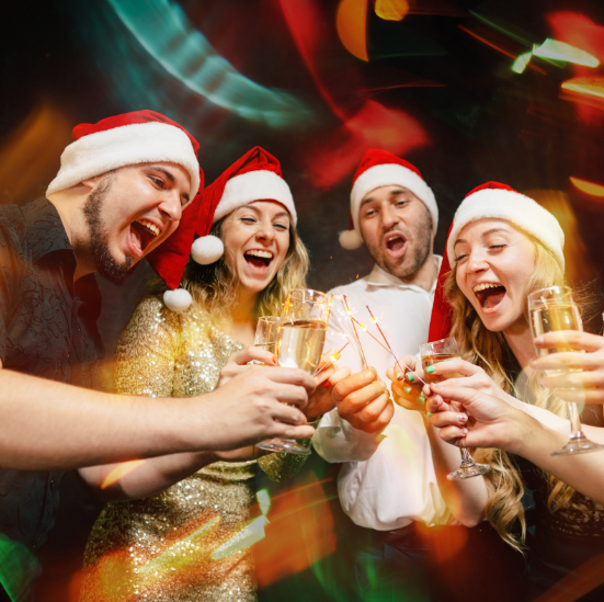 Group of people in Santa hats cheering their drinks